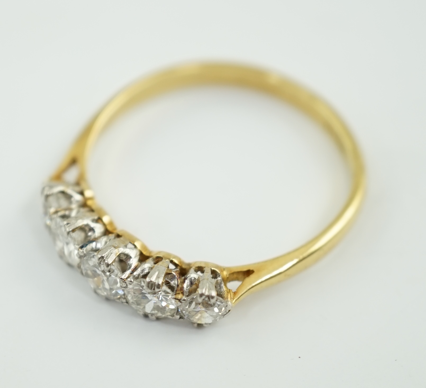 An 18ct gold and graduated five stone diamond set half hoop ring